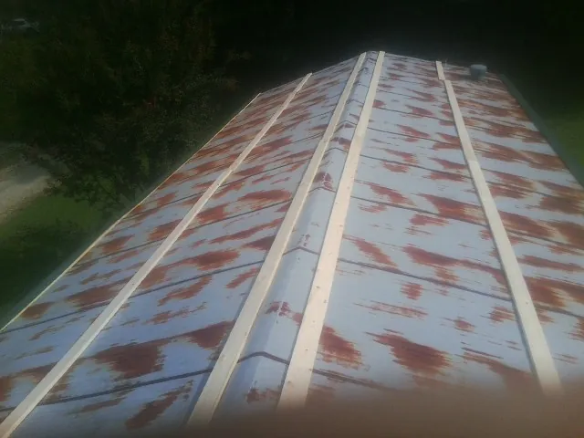 Rusted metal roof panels with new wood purlins before replacement — Storm Damage Roof Repair in Minoa by Roofing Brothers