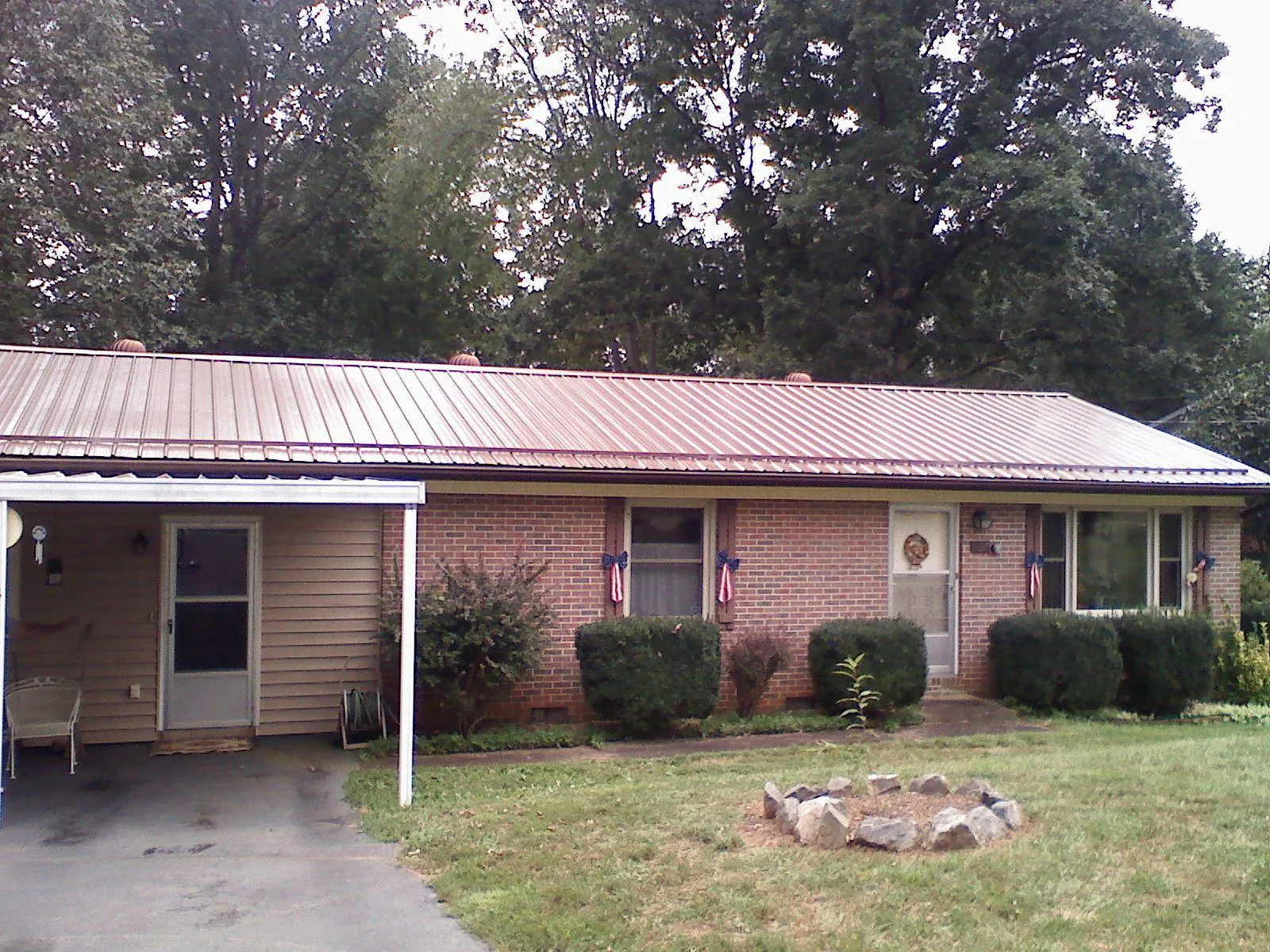 Bronze metal roof and carport on a brick ranch home — Roof Repair work by our crew in Minoa